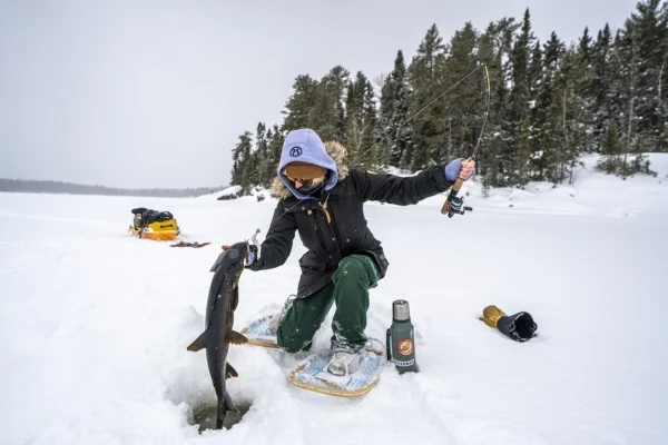 Ice fishing on frozen lake Norway