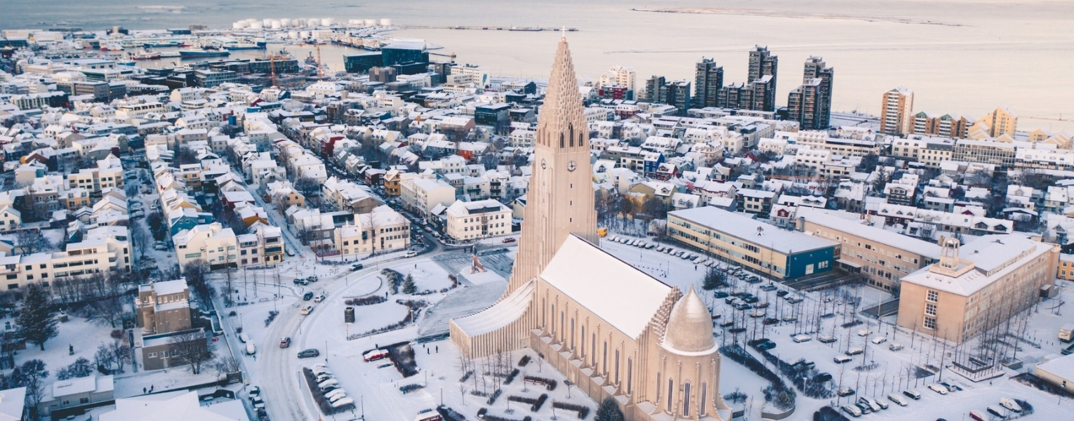 Travelers relaxing in the geothermal waters of the Sky Lagoon with an infinity view of the North Atlantic Ocean.